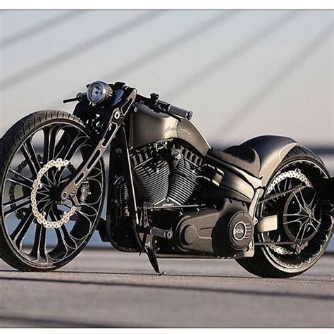 A Black Motorcycle Parked On Top Of A Cement Road