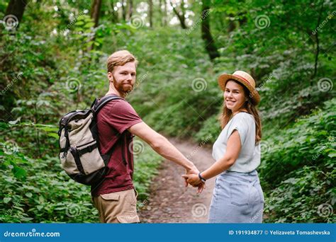 couple holding hands walking in forest back view adventure travel tourism hike people