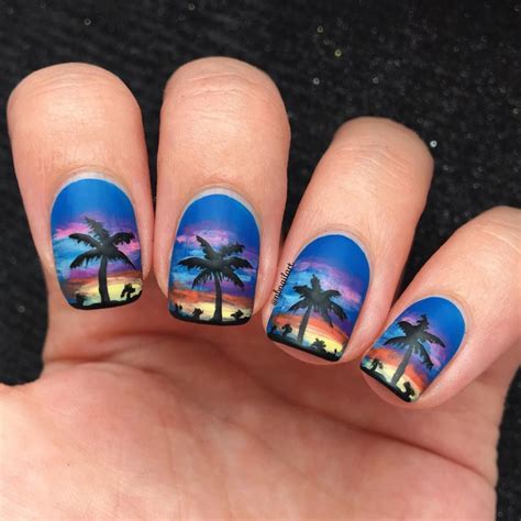 A Person With Palm Trees Painted On Their Nails Is Holding Up Her