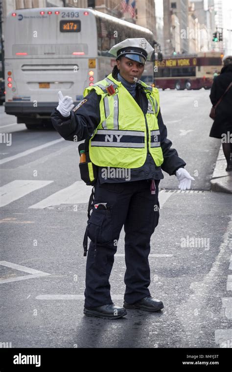 a female traffic cop directing traffic on fifth avenue in midtown manhattan new york citysafety