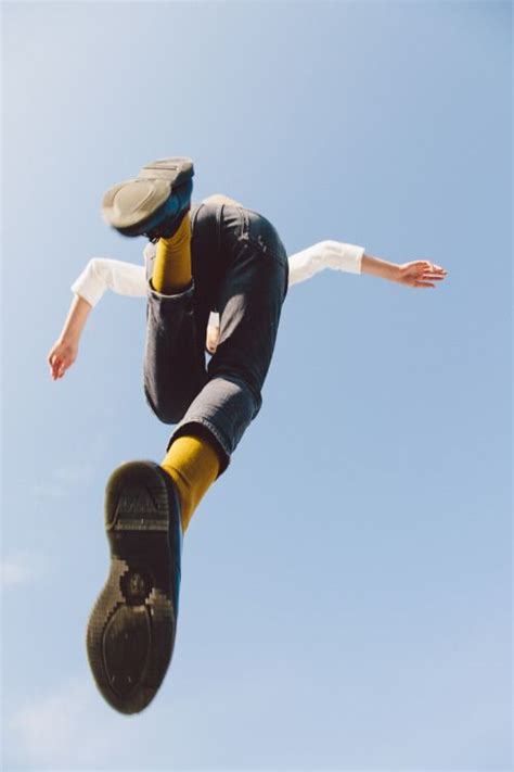 A Man Flying Through The Air While Riding A Skateboard In Front Of A