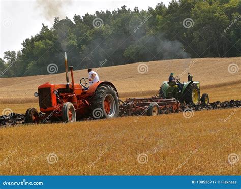 Tractores Del Caso Y De John Deere Que Aran El Rastrojo Del Trigo