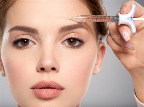 Woman Getting Cosmetic Injection Of Botox In Forehead Closeup Stock