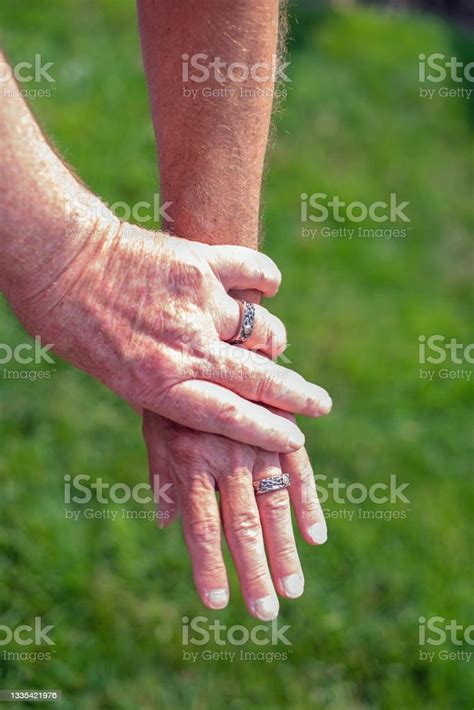 Mature Married Gay Couple Hold Hands To Show Off Wedding Rings Stock