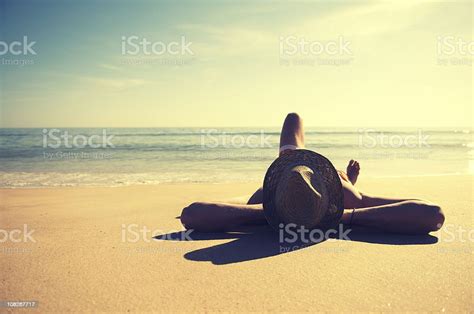 Traveling Man Relaxing On Tranquil Vintage Beach Wearing Hat Stock