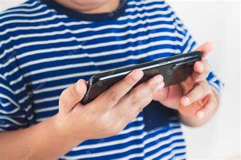 Premium Photo Fat Asian Kids Playing Games On Smartphones
