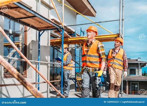 Group Of Handsome Builders Working Together Stock Photo Image Of