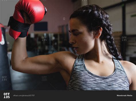 Female Boxer In Boxing Gloves Showing Muscle In Fitness Studio Stock