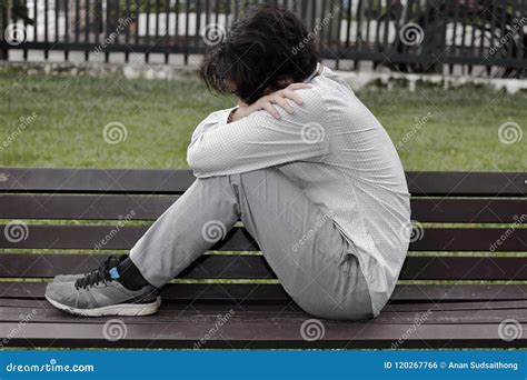 Lonely Depressed Asian Man Sit And Hug His Knee And Cry On The Bench