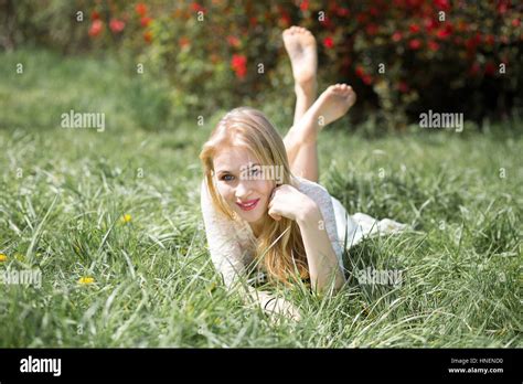 Blonde Young Woman Lying On The Grass With Raised Legs Girl Lovely Smiling And Enjoying