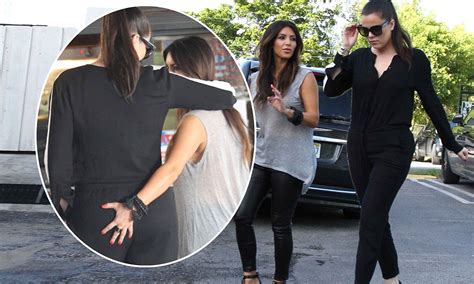 kim kardashian is caught pinching sister khloe s bottom as they film reality show in miami