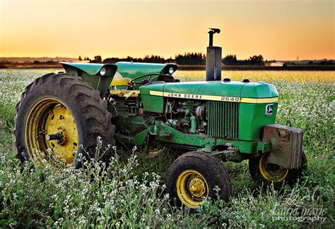 John Deere Tractor In A Field Of Flowers At Sunset Laurie Hunsaker