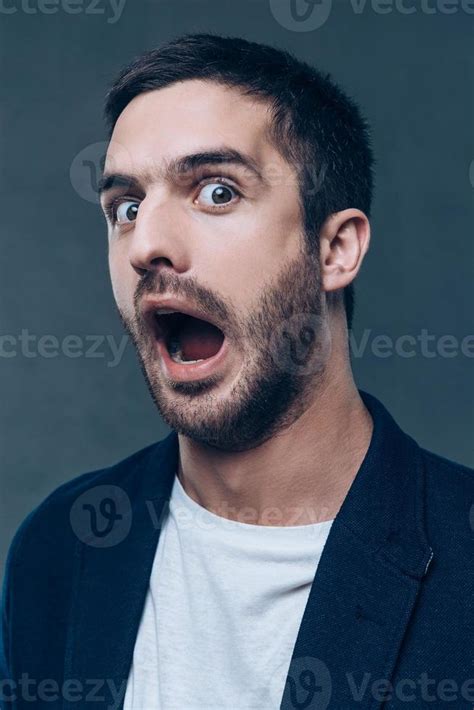 Stupid Face Portrait Of Grimacing Young Man Opening His Mouth And