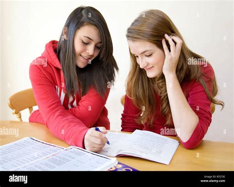 Two Teenage Girls Doing Homework One Helping The Other Stock Photo Alamy