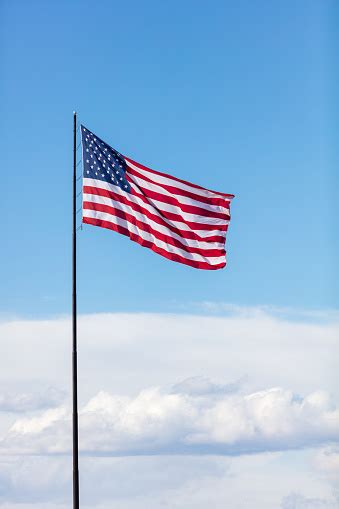 United States American Flag On A Sunny Windy Day With A Cloudscape