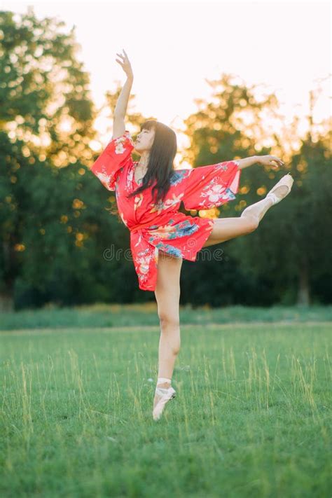 Japanese Ballerina In Red Kimono Stands In Swallow Pose Stock Image