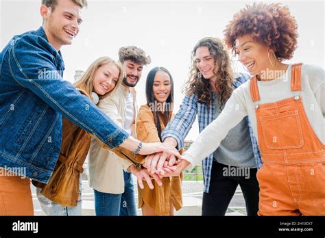Portrait Of Happy University Friends Stacking Hands Together Showing