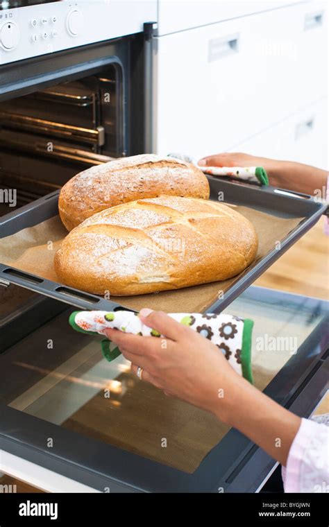 Woman Baking Bread In Kitchen Oven Stock Photo Alamy
