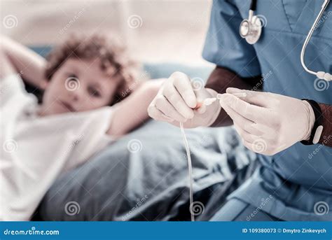 Close Up Of Doctor Adjusting Drip Before Insertion Stock Image Image