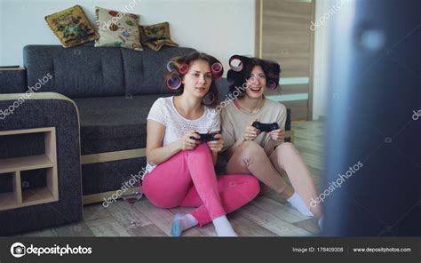 Wählen sie aus illustrationen zum thema lustige spiele zu zweit von istock. Zwei lustige Frauen spielen Konsolenspiele mit Gamepad und ...