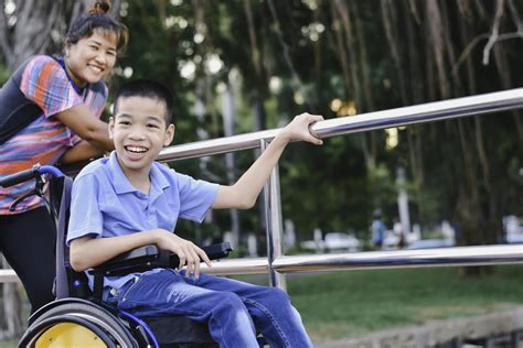 Disabled Child On Wheelchair Is Play And Learn In The Outdoor Park Like