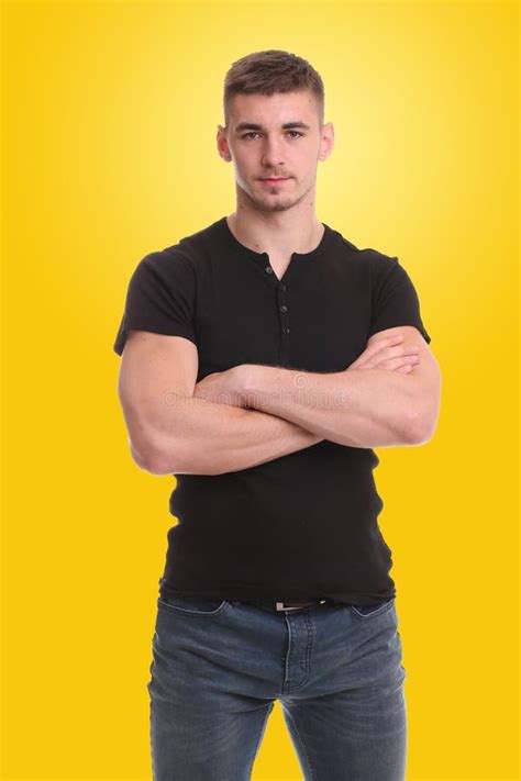 Handsome Young Man Standing With Arms Folded Over Yellow Background
