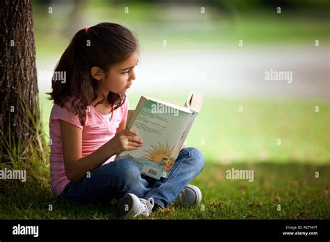 Girl Sitting Alone Outside While Reading A Book Stock Photo Alamy