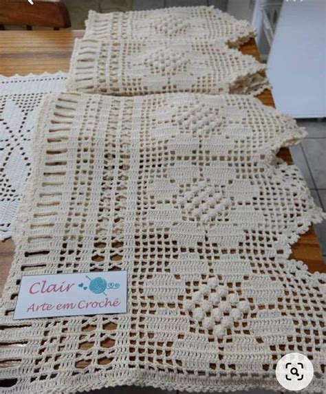 Two Crocheted Bedspreads Sitting On Top Of A Wooden Table