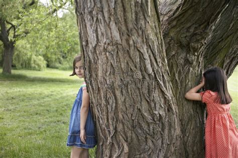 Girls Playing Hide And Seek By Tree Stock Image Image Of Cute Game