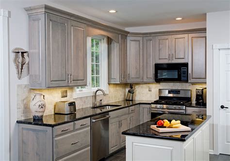 A Kitchen With Gray Cabinets And Black Counter Tops