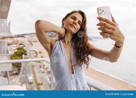 Beautiful Young Caucasian Girl Stands On Balcony Holds Hand On Neck