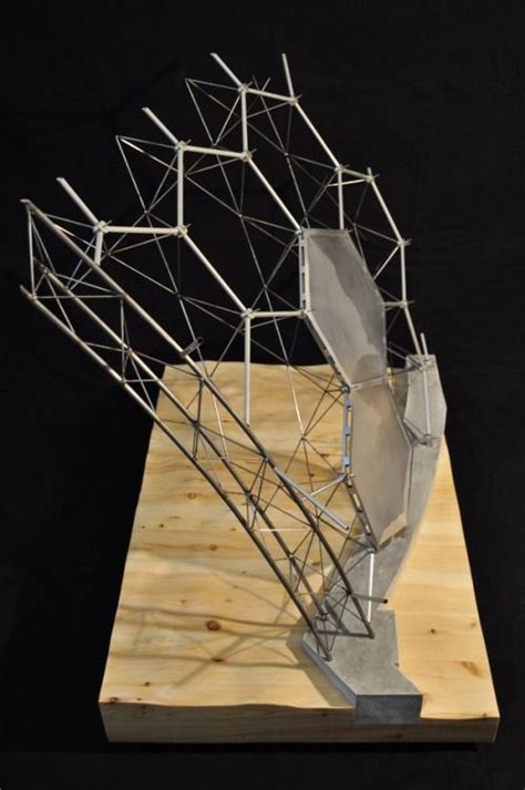 A Sculpture Is Sitting On Top Of A Piece Of Plywood And Has Metal Bars
