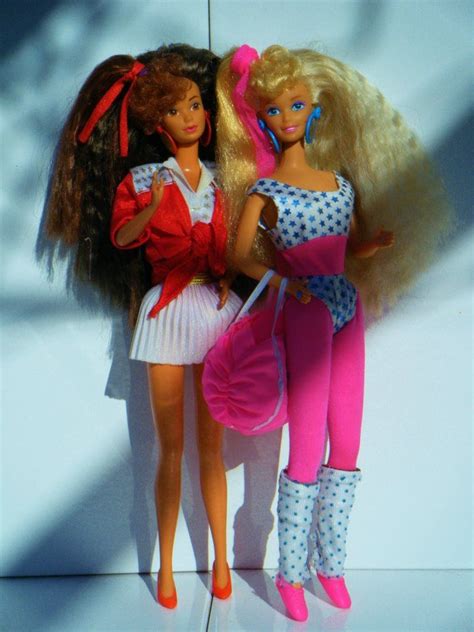 Two Barbie Dolls Standing Next To Each Other