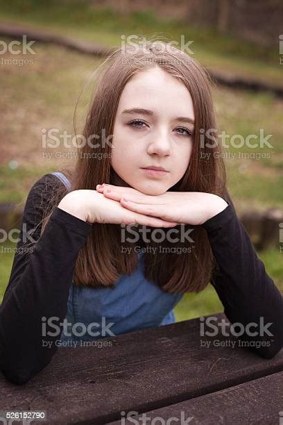 Pretty Teenage Girl Sitting Outdoors At A Picnic Table Stock Photo