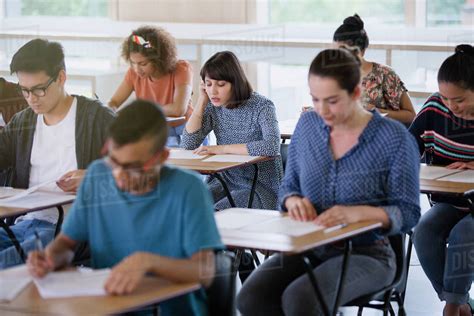 College Students Taking Test At Desks In Classroom Stock Photo Dissolve