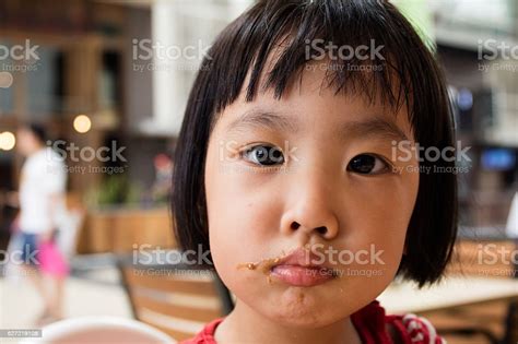 Asian Little Chinese Girl Making A Mess With Food Stock Photo