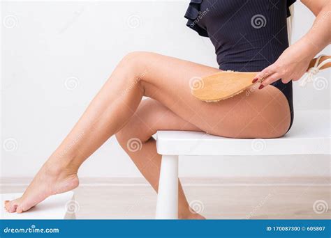 beautiful woman making a scrub massage with big brush dry body brush woman dry brushing body