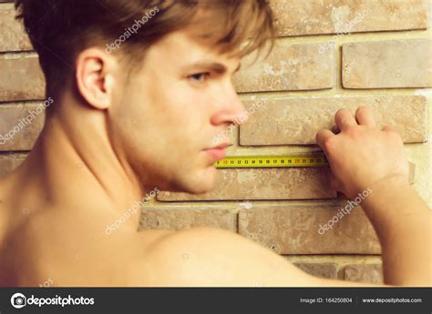 Man With Naked Body Holds Yellow Self Retracting Tape Measure Stock