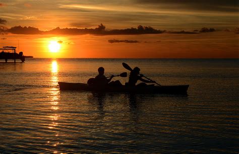 Couple Kayaking At Beautiful Sunset At Tropical Location Of Florida