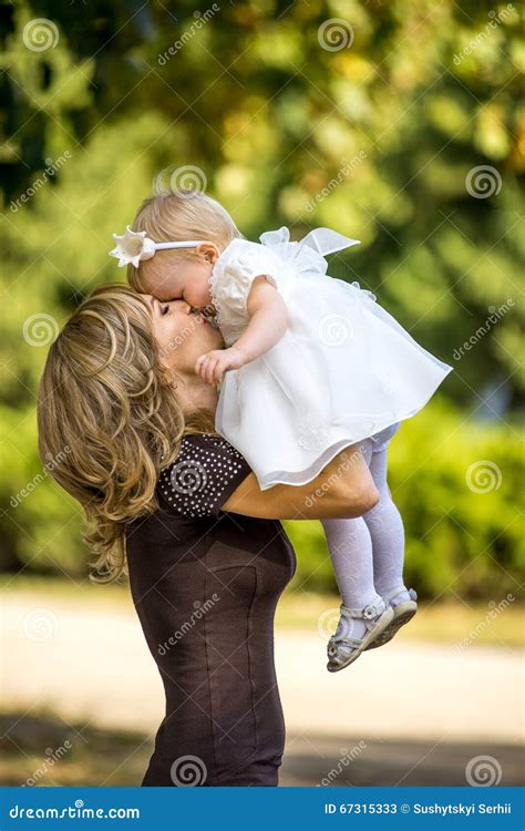 Mother Walks With The Child In The Garden In Summer Stock Image