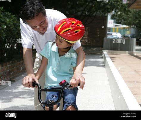 Hombre Maduro Enseñando A Su Nieta Cómo Montar En Bicicleta Fotografía