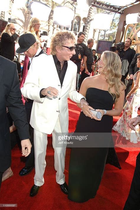 Two Men In White Suits And One Woman In Black Dress On The Red Carpet