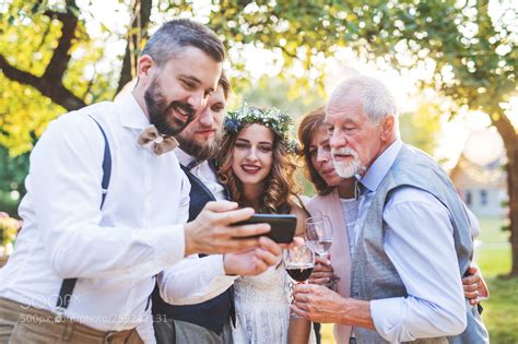 Bride Groom And Guests With Smartphones Taking Selfie Outside At