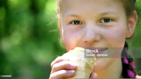 Portrait Pretty Girl Of Eight Years Blonde With Freckles Eating White Ice Cream In A Waffle Cup