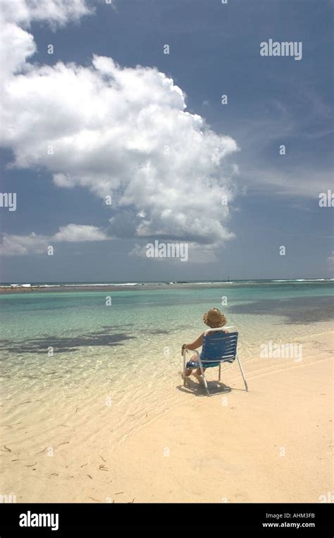 Woman Sitting In A Chair On A Beach In Cayman Brac Cayman Islands Stock Photo Alamy