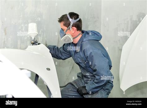 Worker painting white car Stock Photo - Alamy