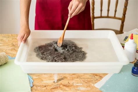 Free Photo Womans Hand Stirring Paper Pulp In Water
