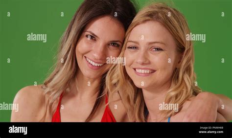 Portrait Of Two Female Best Friends In Bikinis Smiling At Camera On