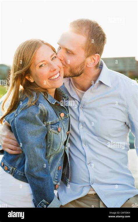 Man Kissing Woman On Cheek Stock Photo Alamy