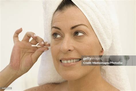 Mid Adult Woman Cleaning Her Ear With A Cotton Swab High Res Stock